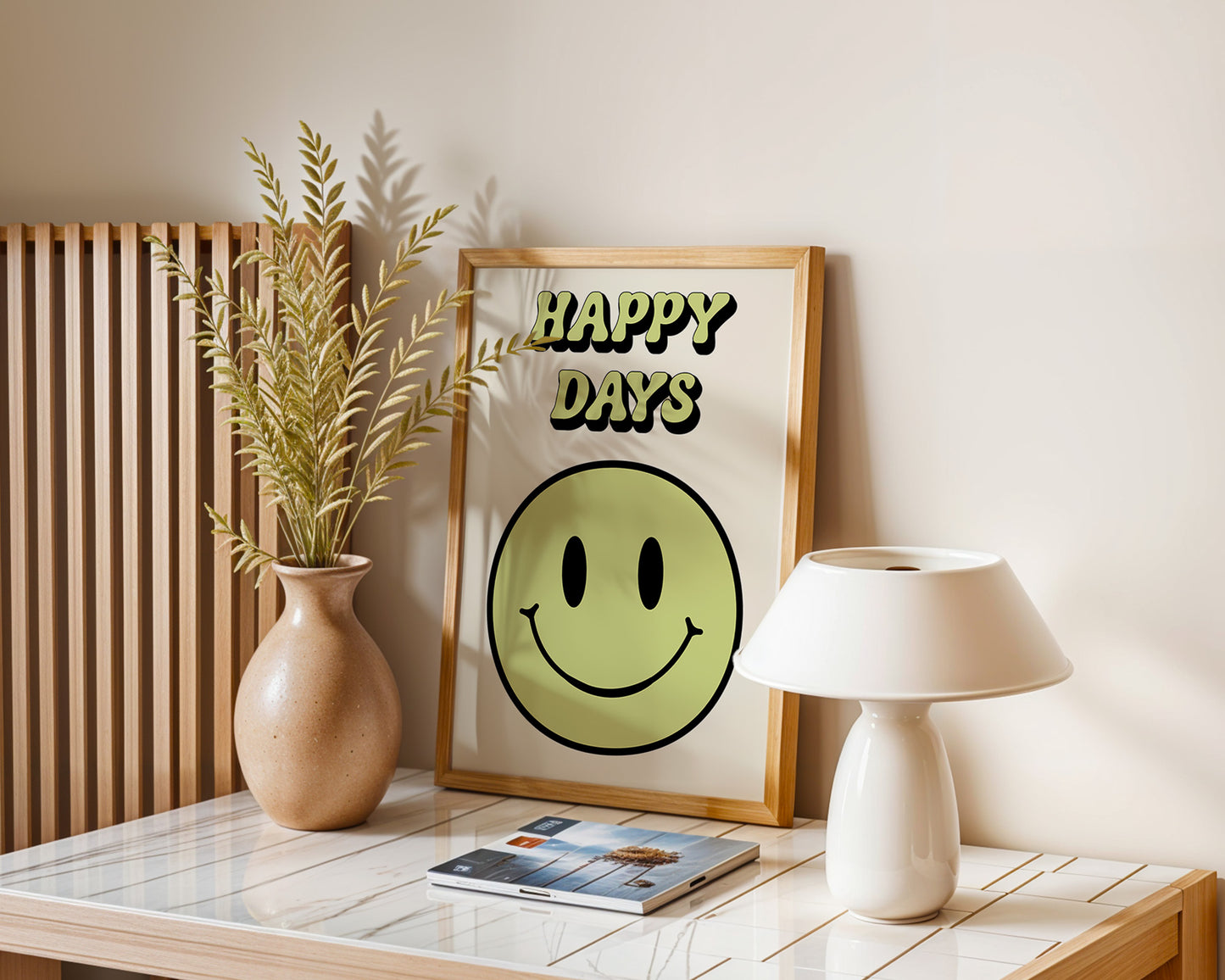 A series of 'Happy Days' retro art prints with various colored smiley faces displayed on a wall, below a window with natural light coming in and a plant to the side.