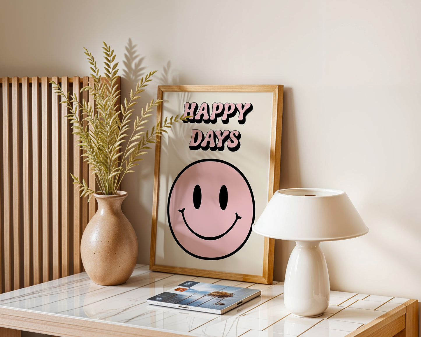 A series of 'Happy Days' retro art prints with various colored smiley faces displayed on a wall, below a window with natural light coming in and a plant to the side.