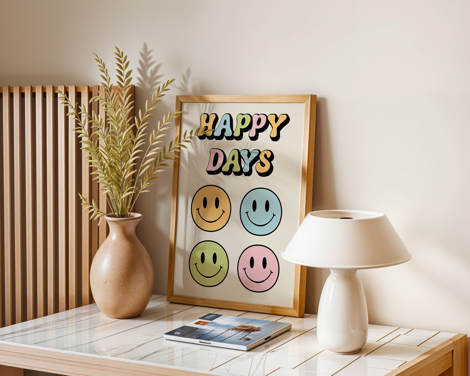 A series of 'Happy Days' retro art prints with various colored smiley faces displayed on a wall, below a window with natural light coming in and a plant to the side.