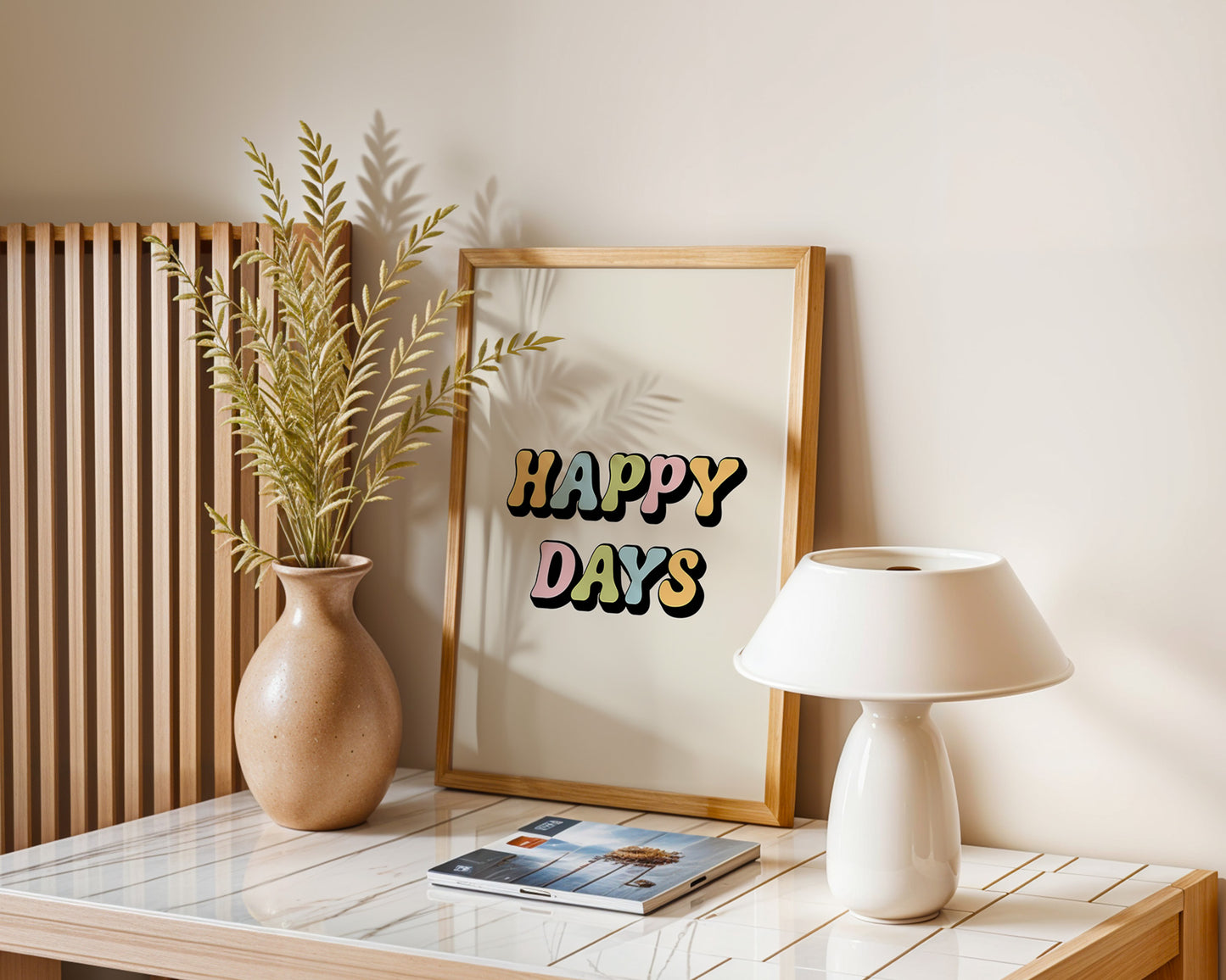 A series of 'Happy Days' retro art prints with various colored smiley faces displayed on a wall, below a window with natural light coming in and a plant to the side.