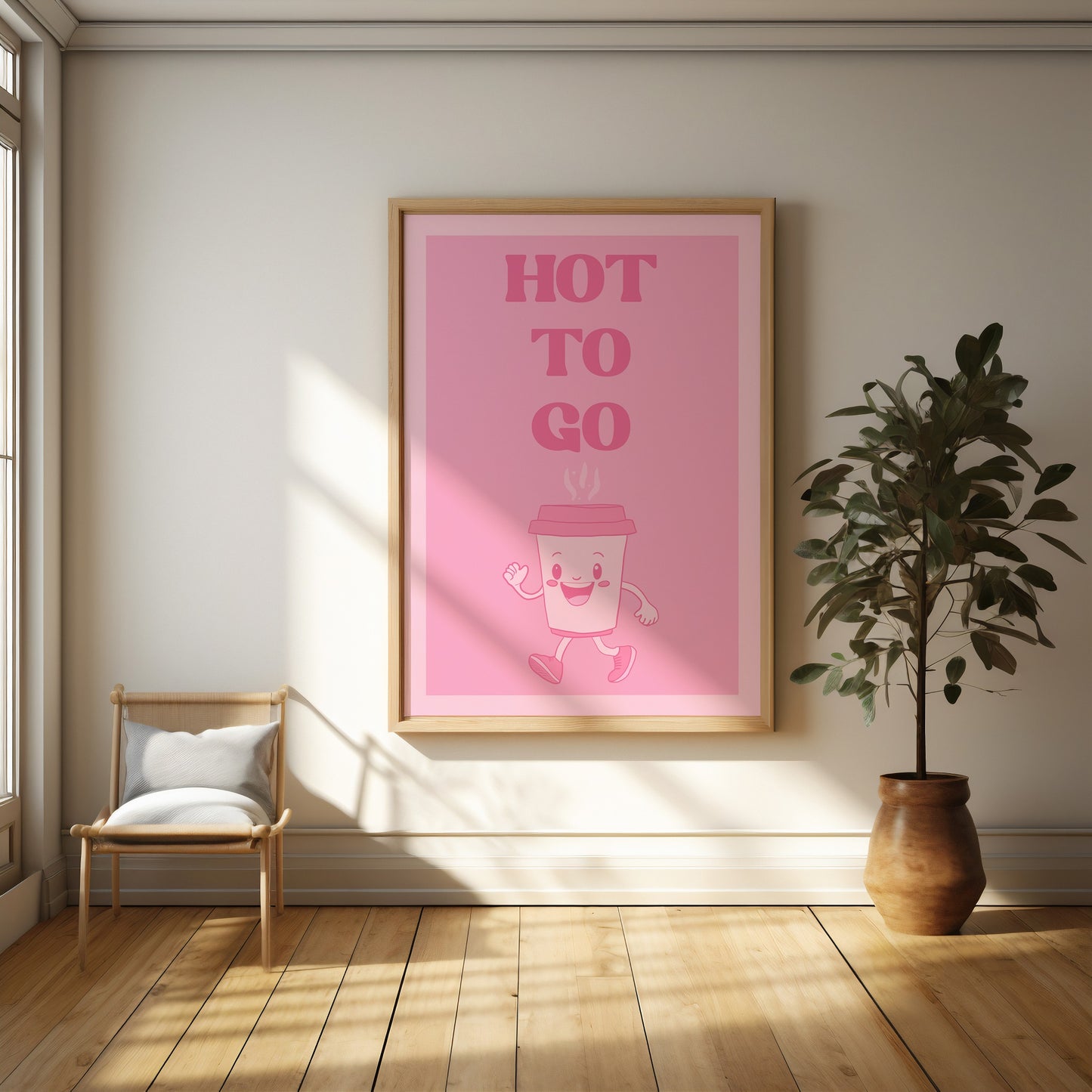 Quirky wall art featuring a smiling cartoon coffee cup with "Hot to Go" text, styled in a modern room with a plant and chair.